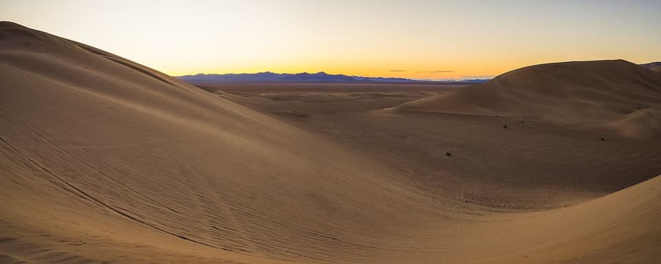 Sand dunes in soft light at sunrise (illustrative)