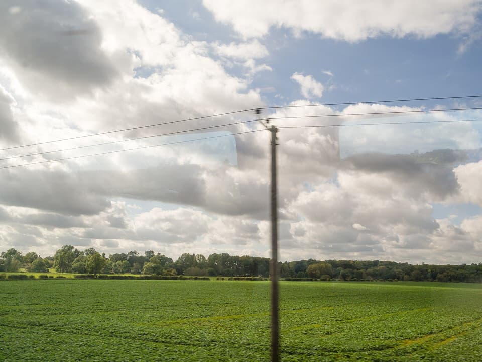 Green fields and big skies seen through a train window (illustrative)